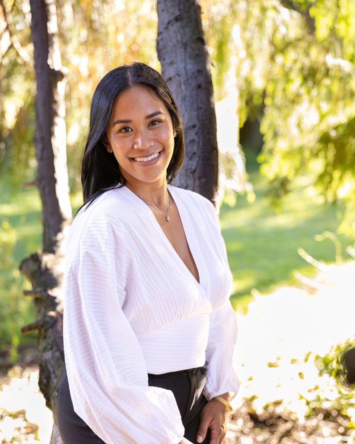 Dr. Monee Dulay smiling outdoors in a white blouse