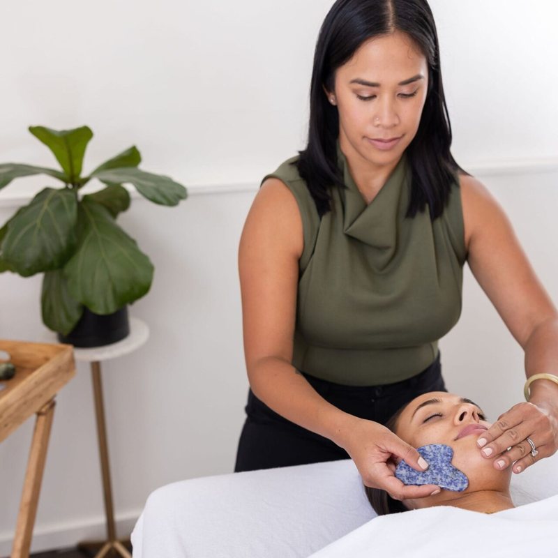 Dr. Monee giving a facial gua sha treatment